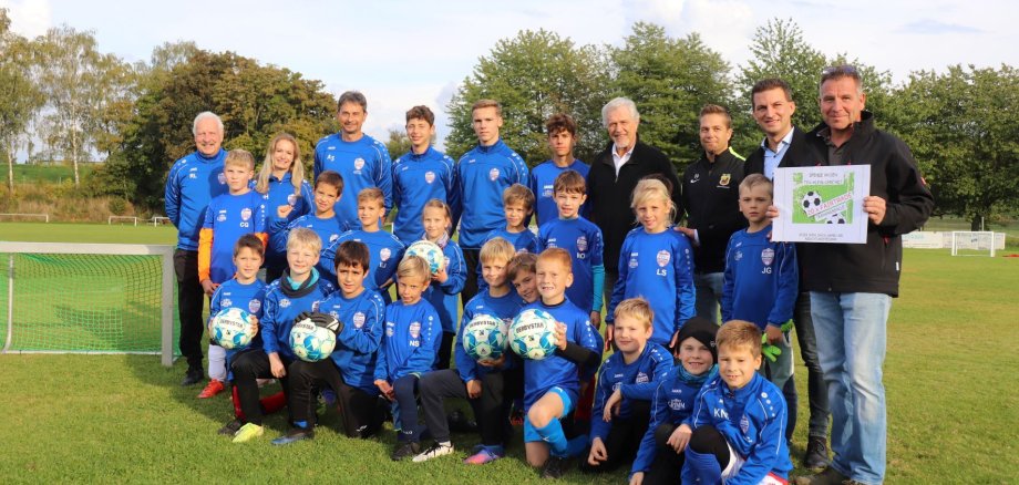 Die F1- und F2-Fußballjugend mit Trainerstab, Bürgermeister Kirch und dem Spender der fairen Bälle, Peter Reger, auf dem Sportplatz in Klein-Umstadt