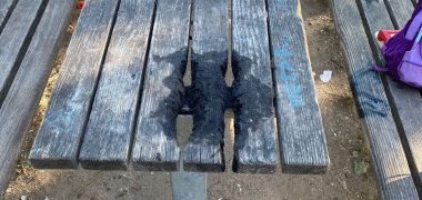 Beschädigte Sitzgruppe Der Tisch weist Brandspuren auf.