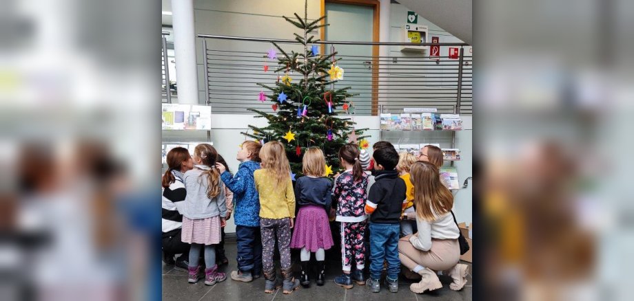 Kinder des Haus der Kinder schmücken Weihnachtsbaum im Rathaus