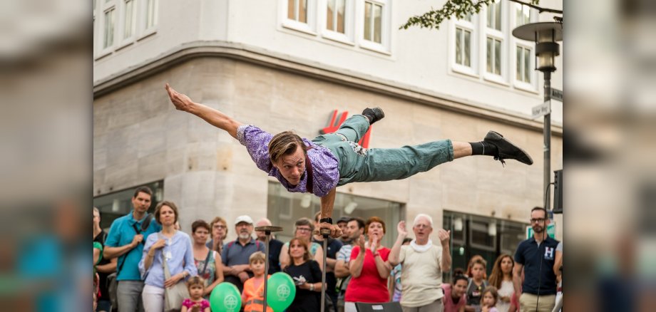 Einarmiger Handstand bei Straßentheater