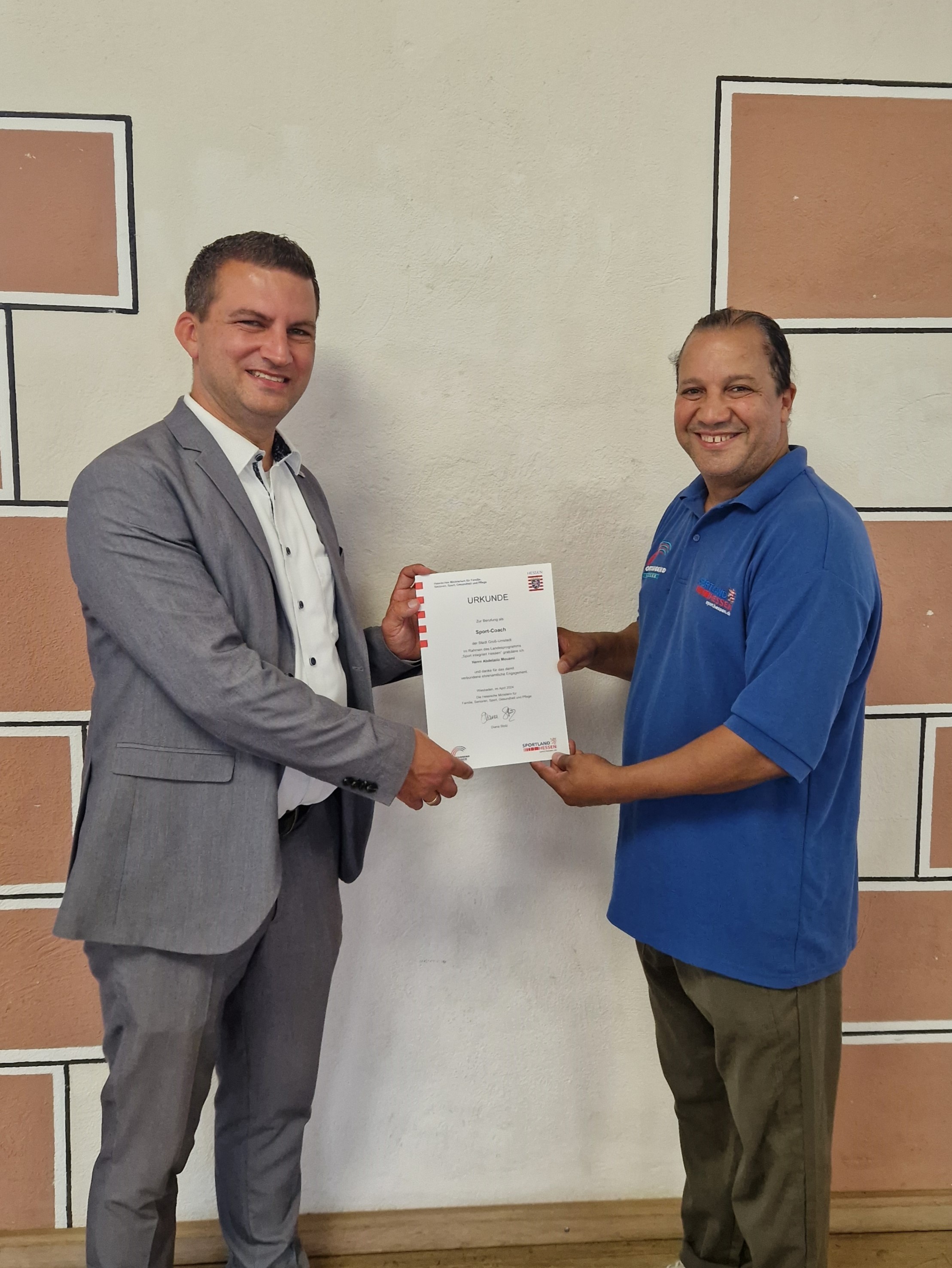 Bürgermeister Kirch übergibt Sportcoach Mouami Urkunde der Förderung