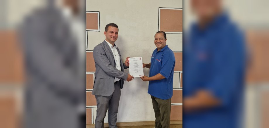Bürgermeister Kirch übergibt Sportcoach Mouami Urkunde der Förderung