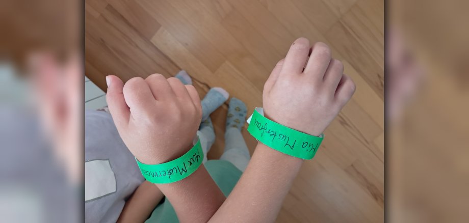Kinderhände mit Kinderfinder-Armbändern