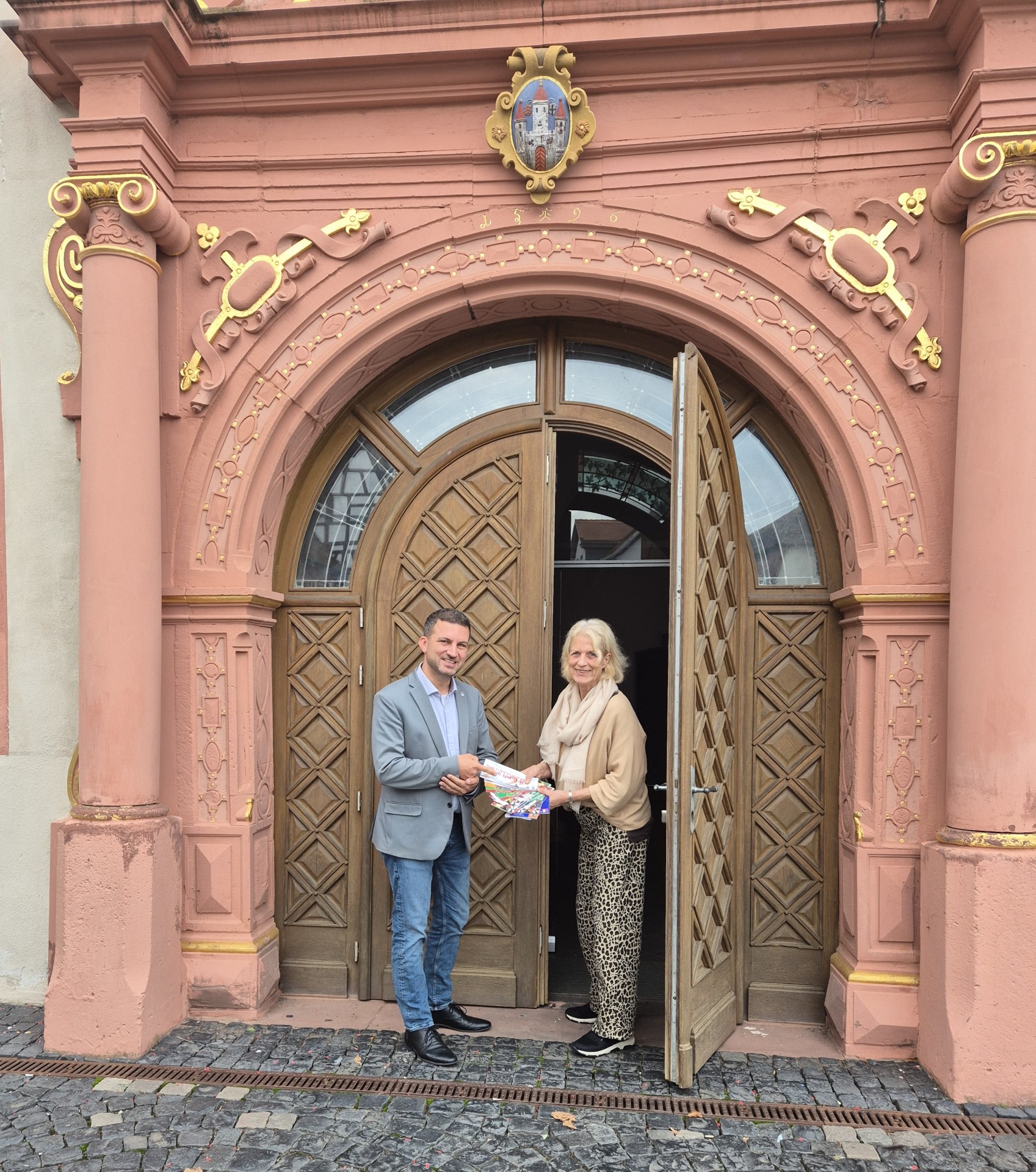 Kulturmanagerin Angelika Borchert übergibt Kulturprogramme an Bürgermeister René Kirch vor dem Kunstforum Säulenhalle