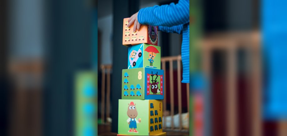 Kind baut Holzklotzturm