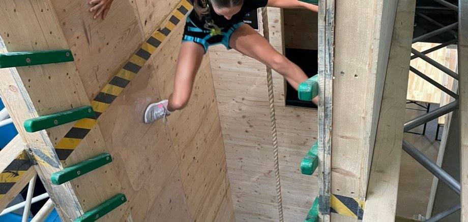 Mädchen in Kletterwand in Kletterhalle