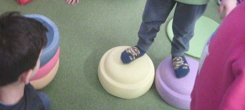 Kind steht auf Stapelsteinen