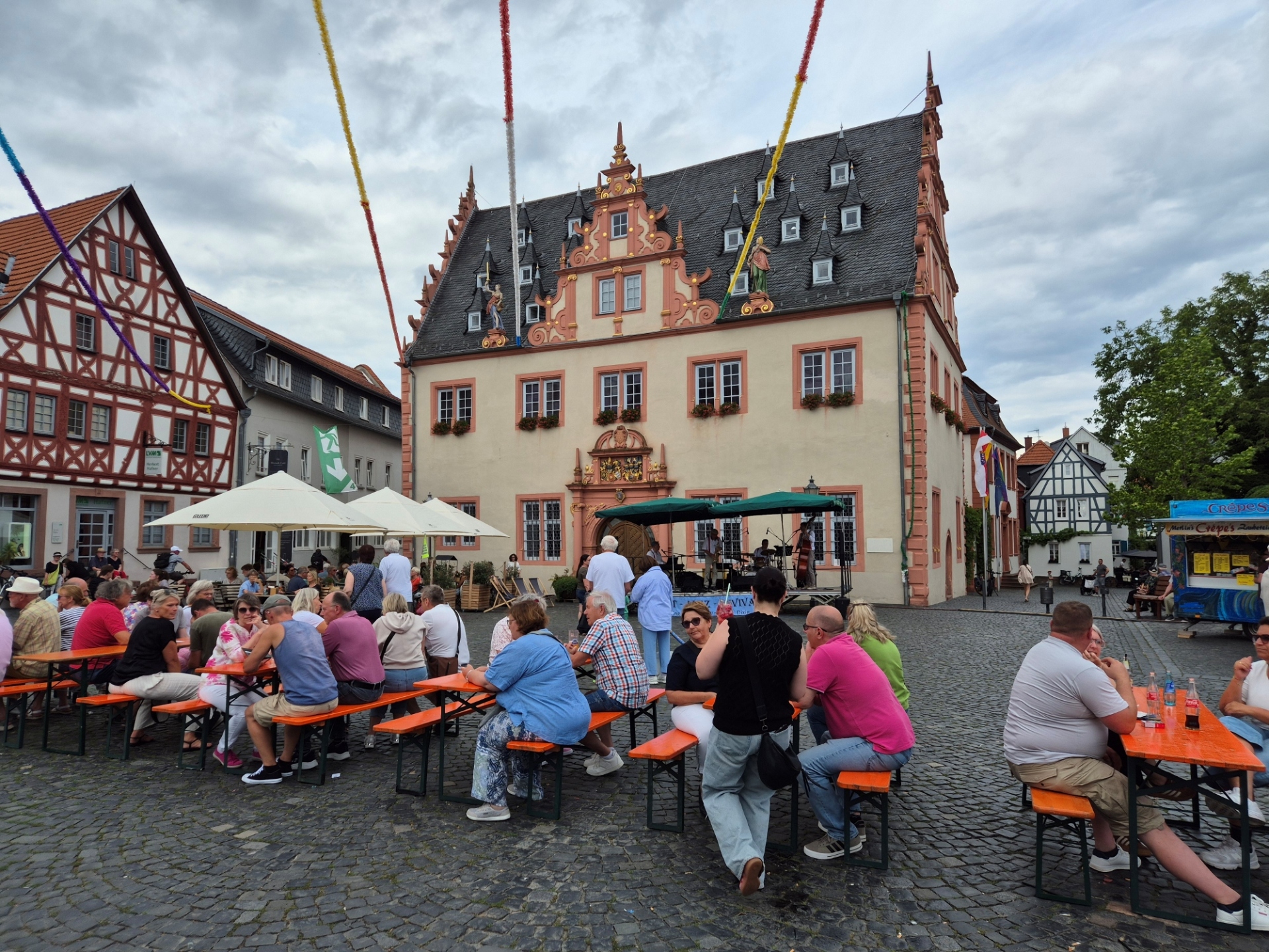Gäste des Jazz Day sitzen auf dem Marktplatz auf Bierzeltgarnituren