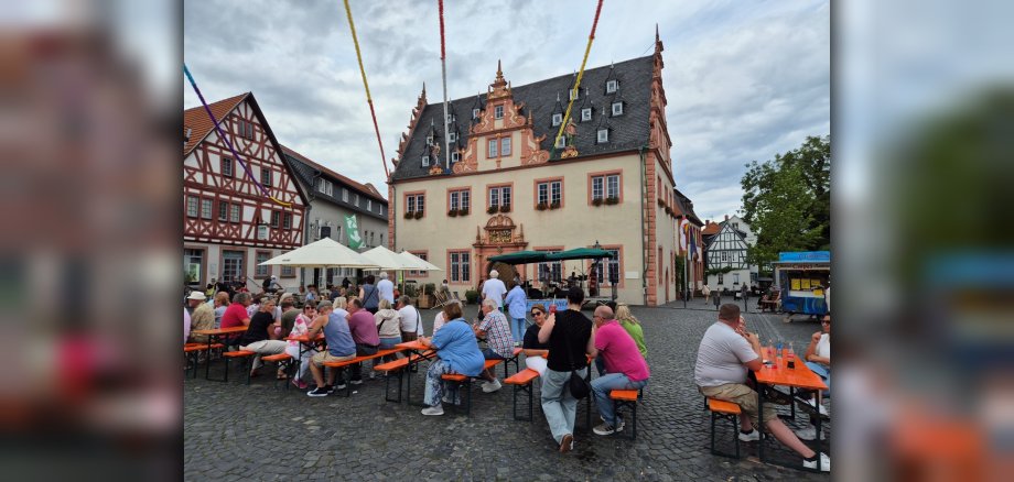 Gäste des Jazz Day sitzen auf dem Marktplatz auf Bierzeltgarnituren