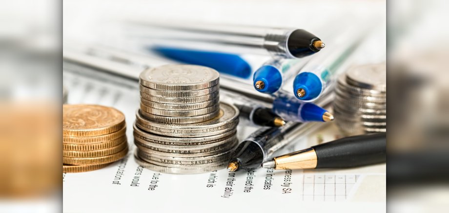 Foto: Münzen, Antragsscheine und Kugelschreiber