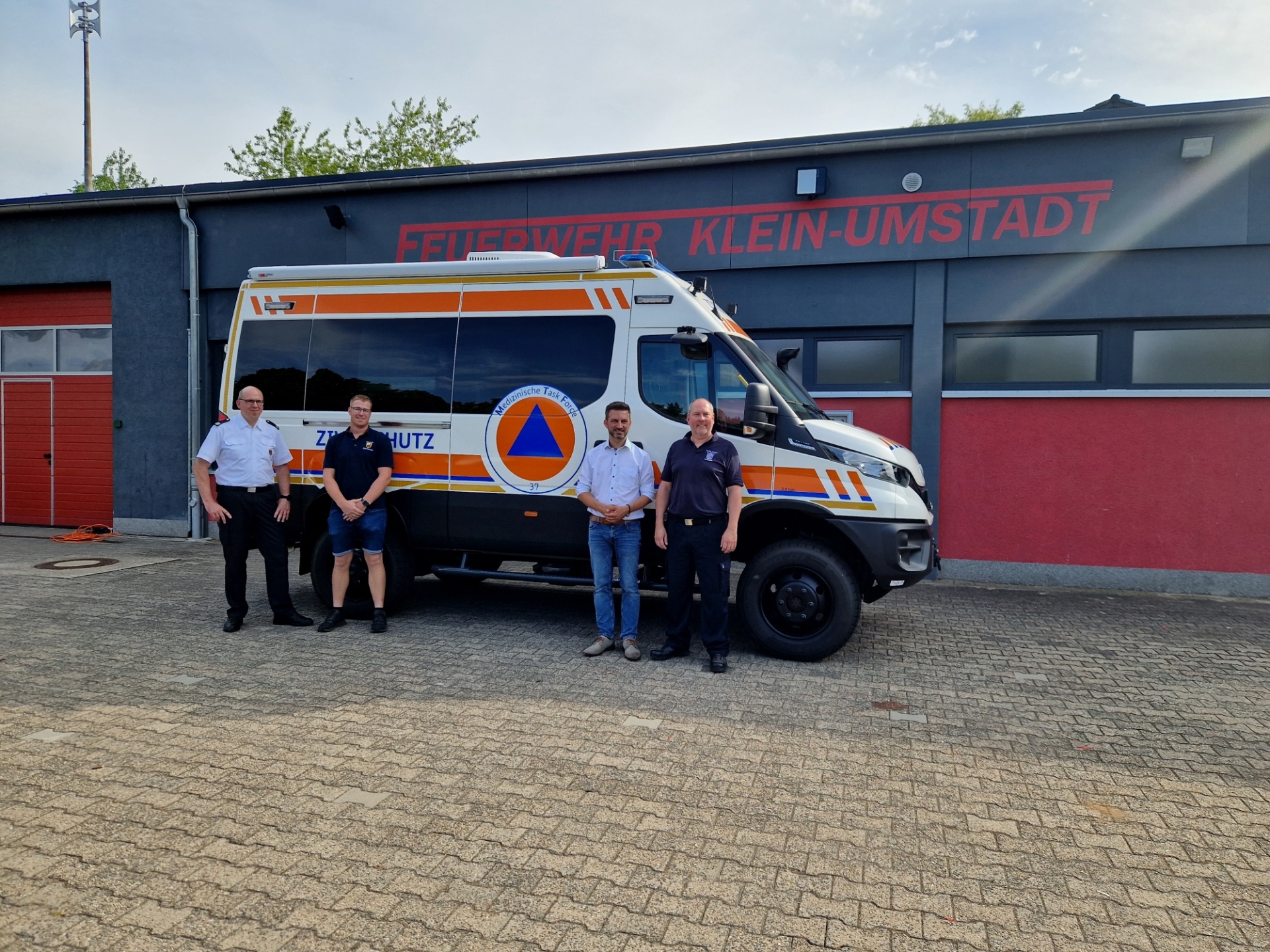 Feuerwehrfahrzeug vor Feuerwehrgebäude