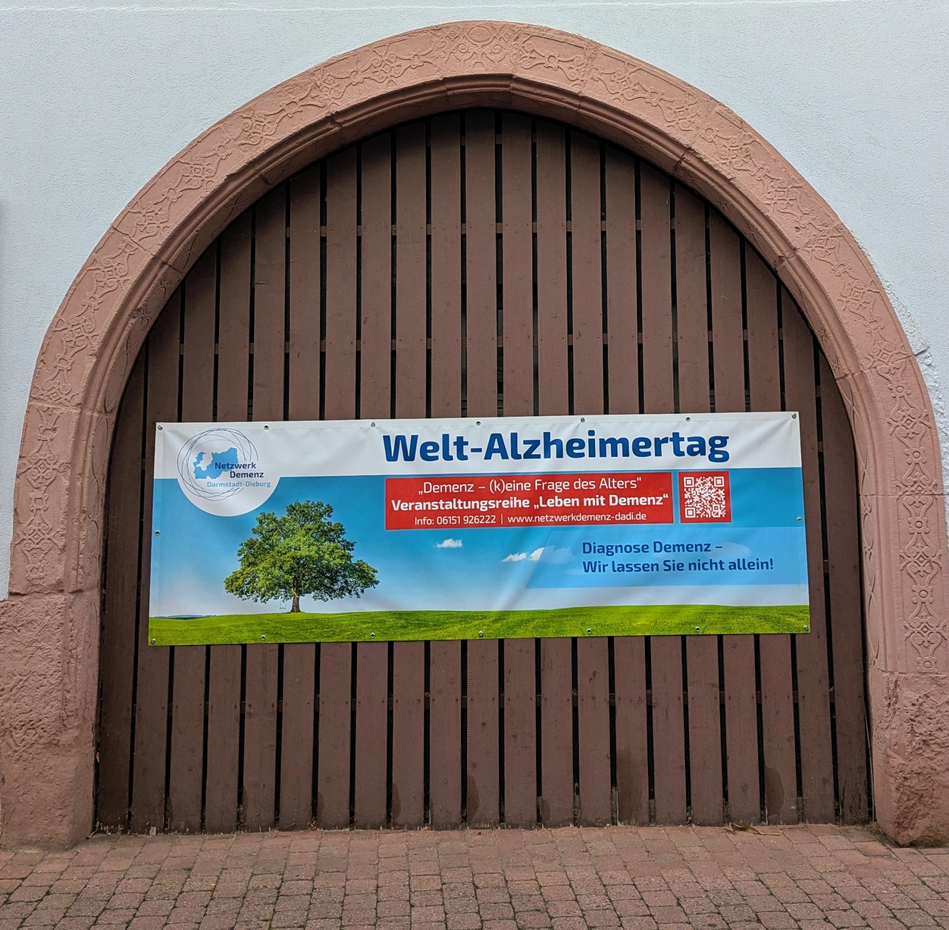 Foto: braunes Hoftor mit Plakat des Welt-Alzheimertages