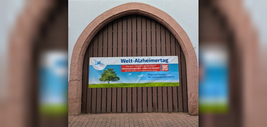 Foto: braunes Hoftor mit Plakat des Welt-Alzheimertages
